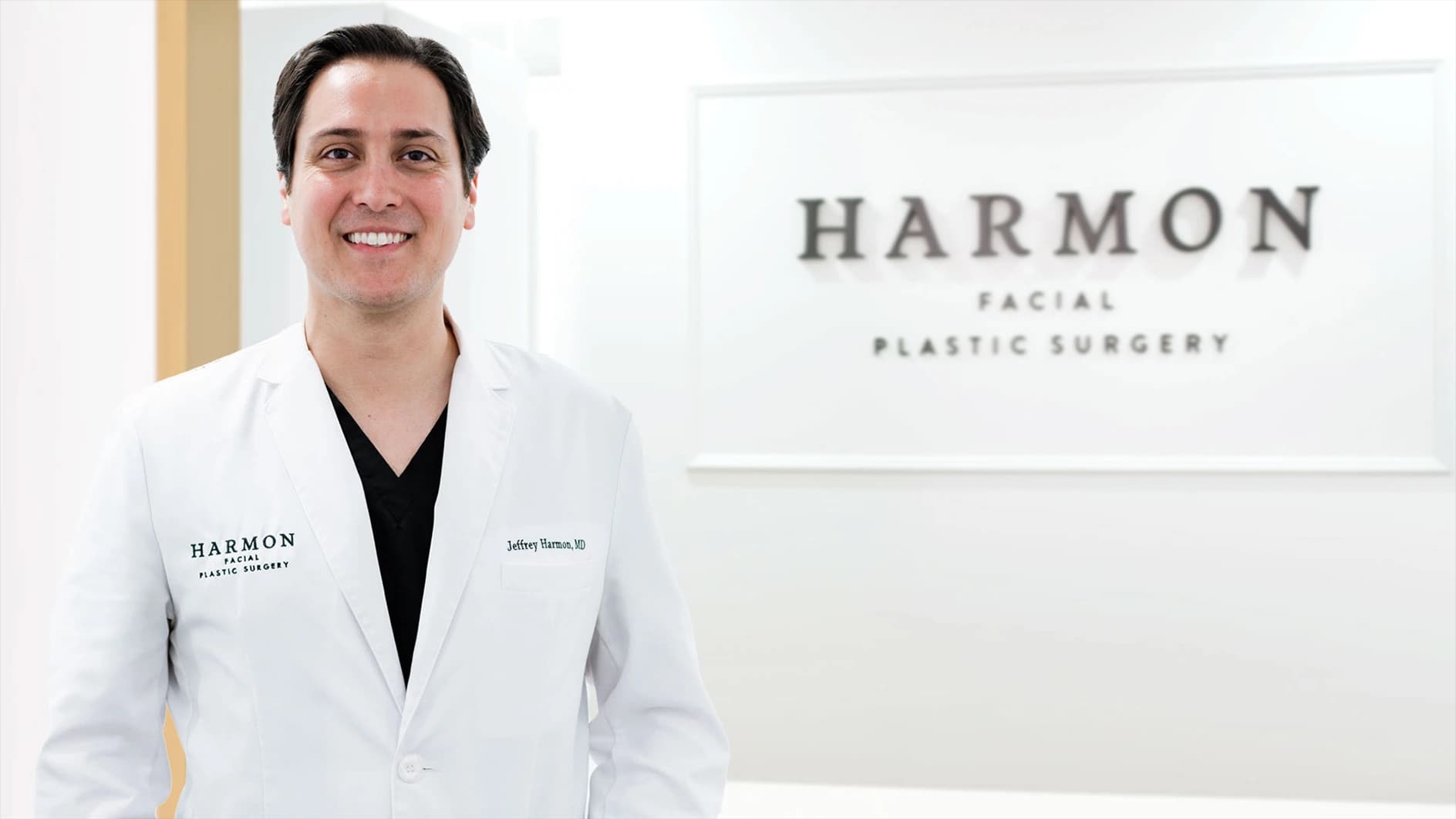Eyelid Bags: Board-certified facial plastic surgeon standing in a modern medical office setting